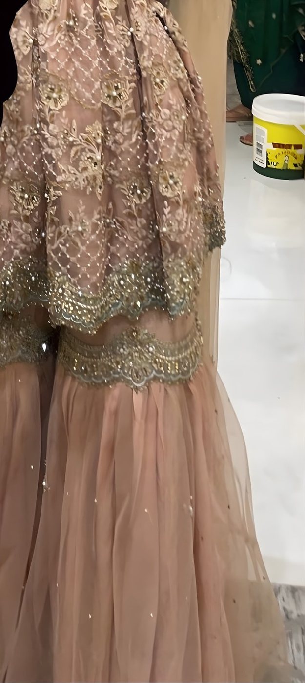 Close detail of gold and pearl hand embroidery on a Tehxeeb London blush lehenga